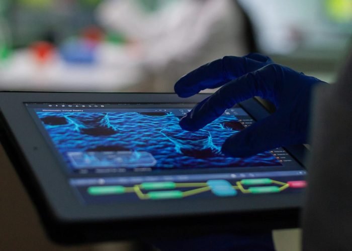 imgi_28_scientist-researcher-doctor-analyzing-genetic-mutation-test-using-tablet-while-her-collegue-typing-biological-expertise-computer